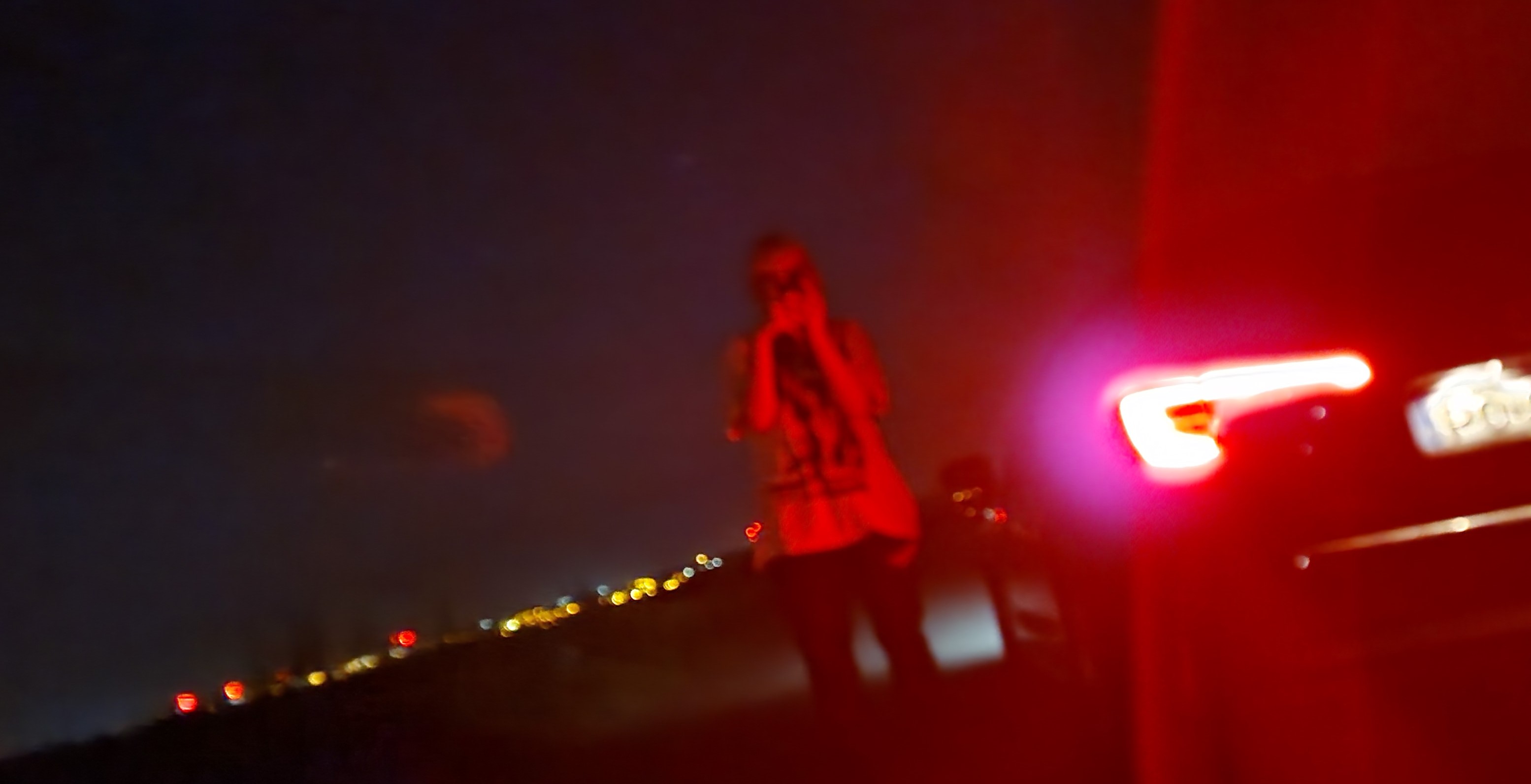 roadside / taillight / city below
